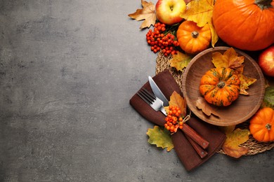 Photo of Flat lay composition with tableware, autumn leaves and vegetables on grey background, space for text. Thanksgiving Day