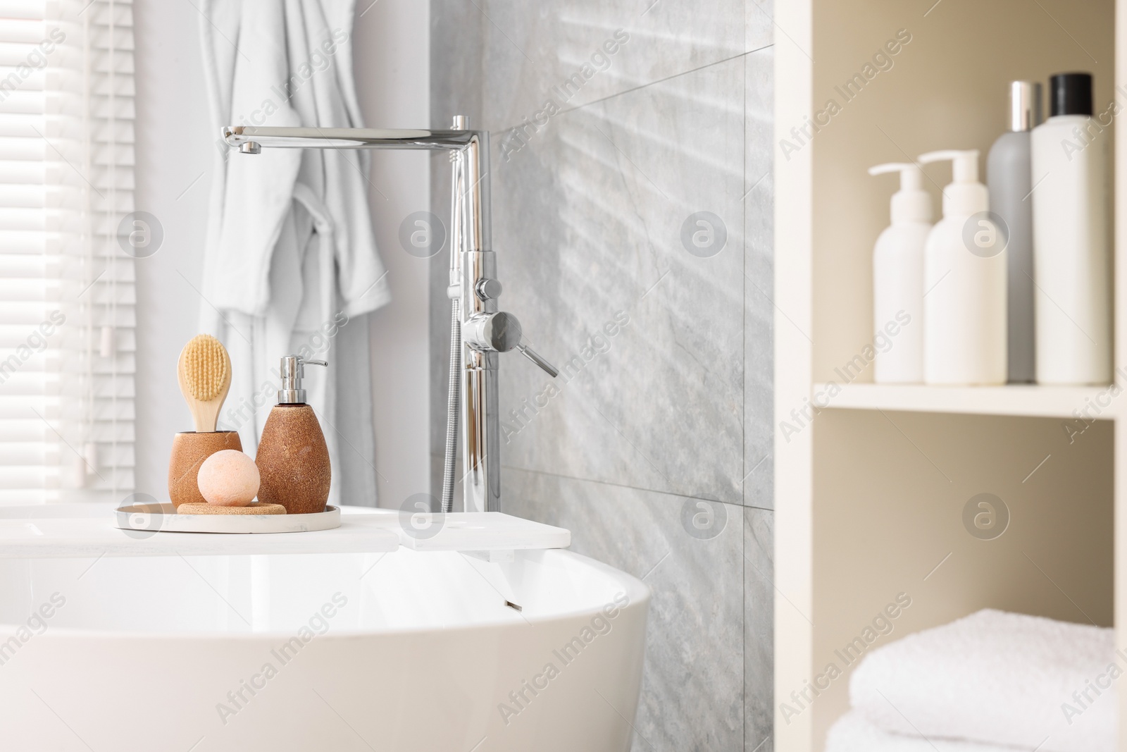 Photo of Different personal care products and accessories on bath tub in bathroom