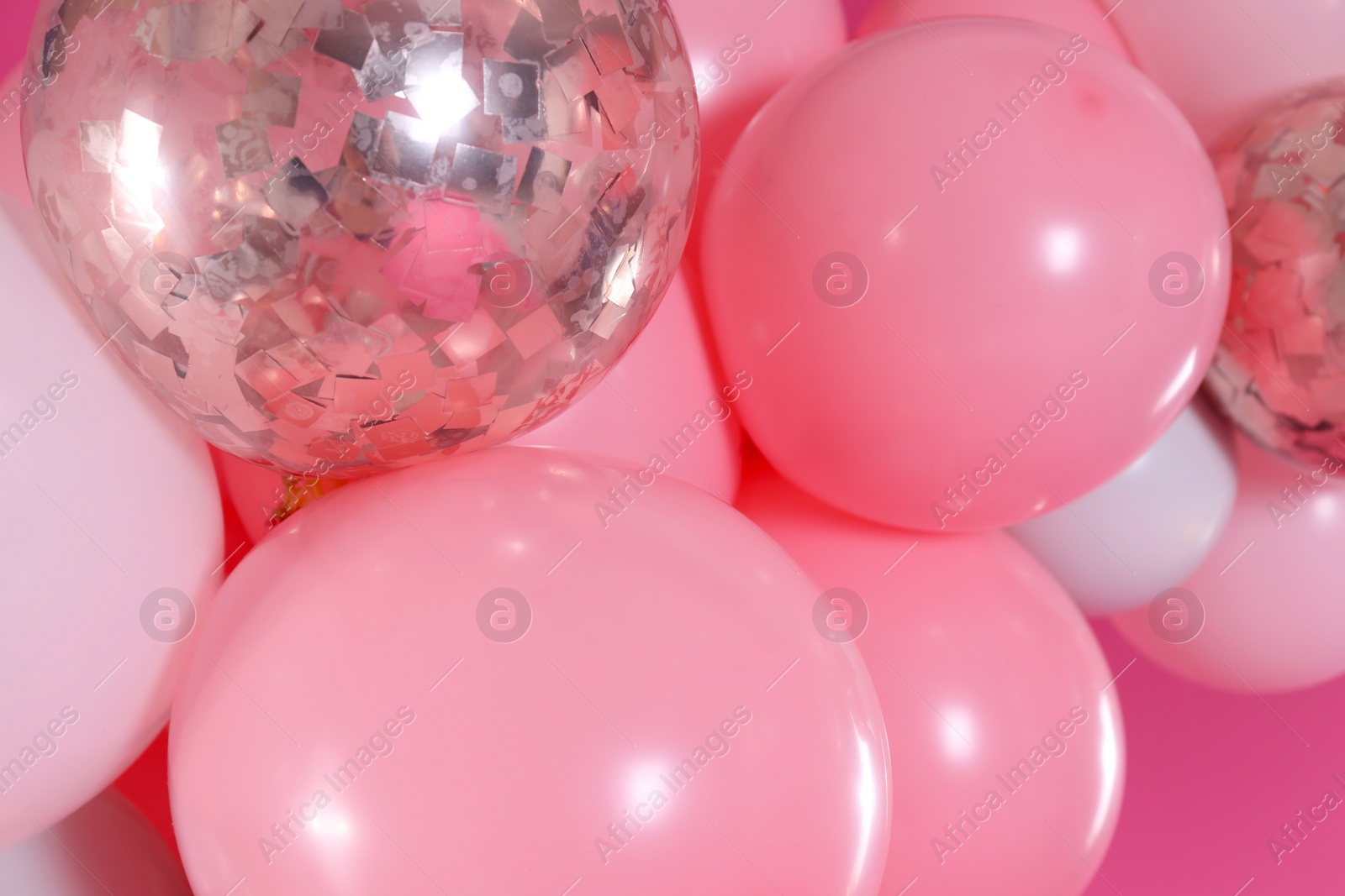 Photo of Beautiful colorful balloons on pink background, closeup