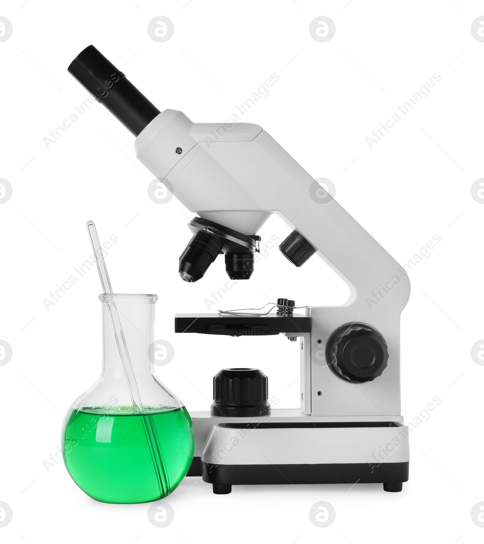 Photo of Laboratory flask with green liquid and microscope isolated on white