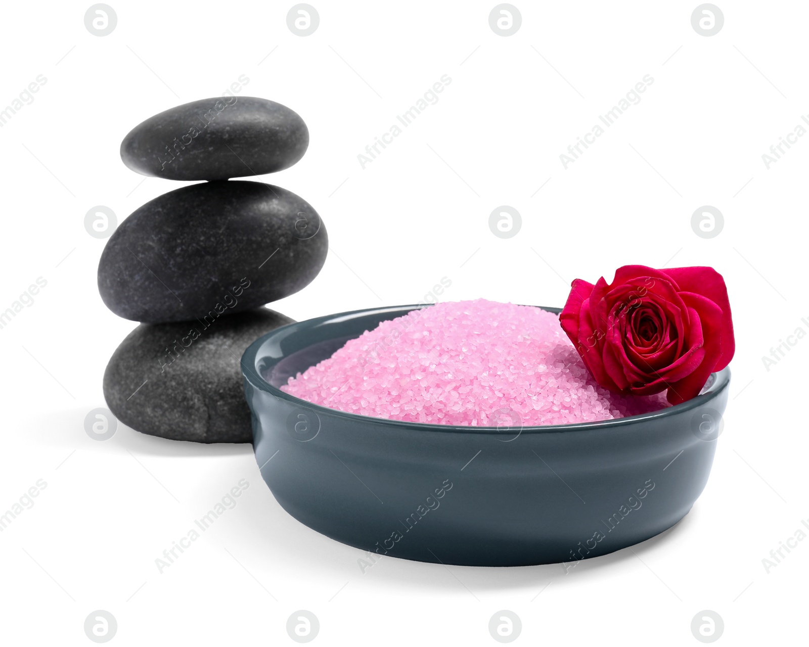 Photo of Pink sea salt in bowl, rose and spa stones isolated on white