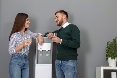 Employees having break near water cooler in office