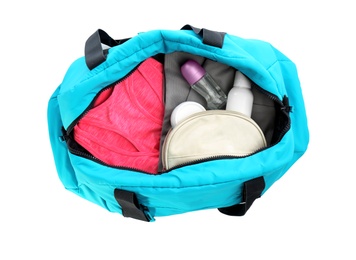 Photo of Sport bag with deodorants and clothes on white background, top view