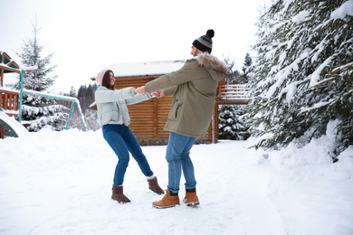 Lovely couple spending time together on snowy day. Winter vacation