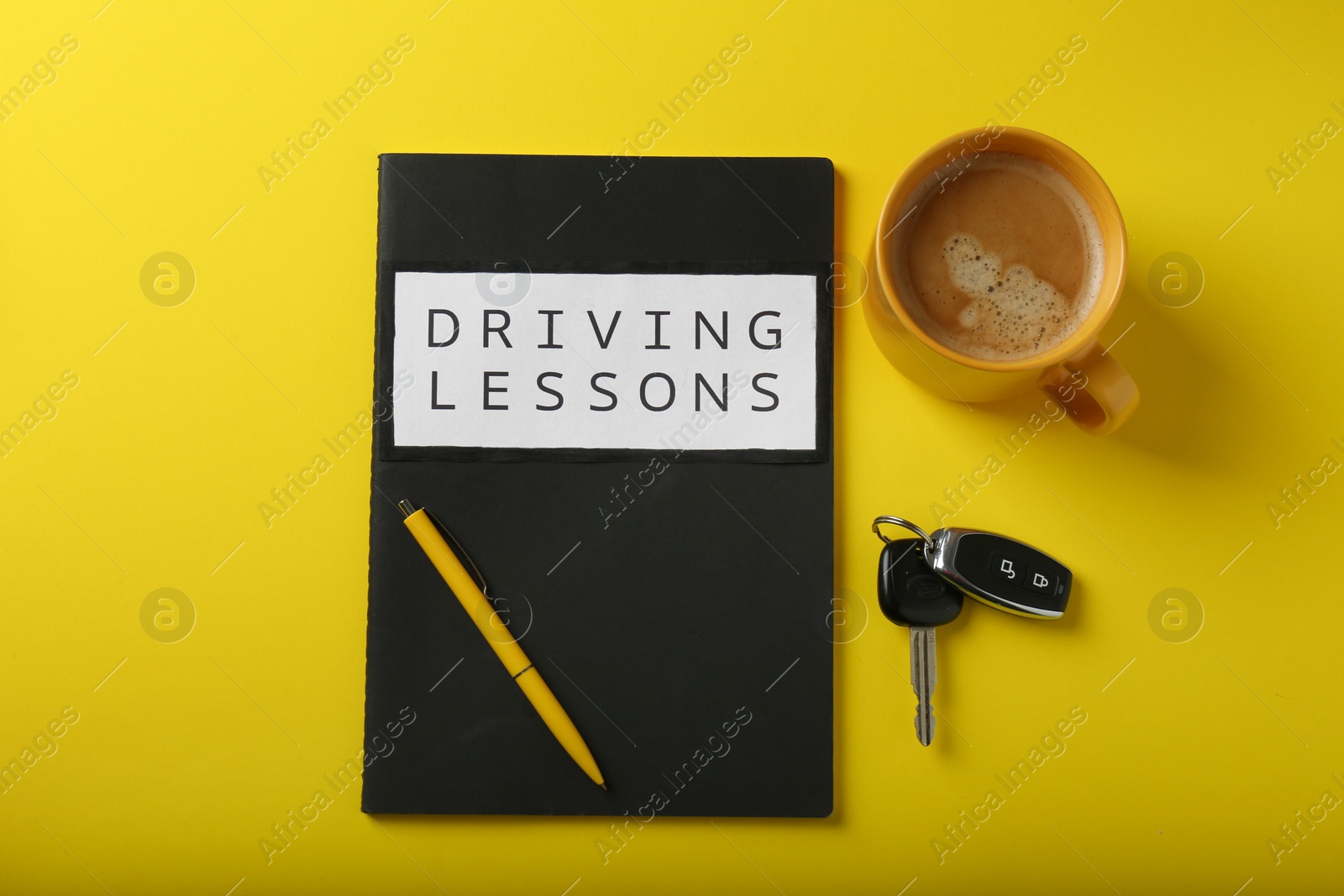 Photo of Flat lay composition with workbook for driving lessons on yellow background. Passing license exam