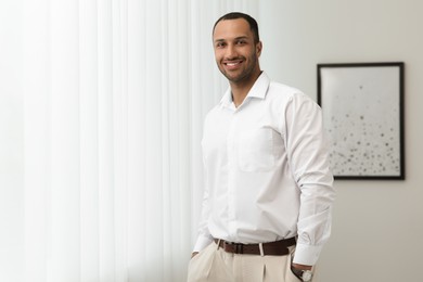 Portrait of handsome young man indoors, space for text