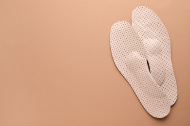 Orthopedic insoles on pale pink background, flat lay. Space for text