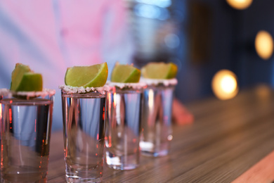 Mexican Tequila shots with salt and lime slices on bar counter