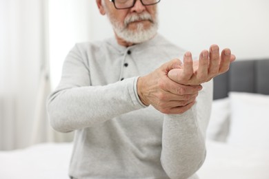 Photo of Arthritis symptoms. Man suffering from pain in hand at home, closeup