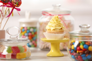 Photo of Candy bar with different sweets on white table against blurred background