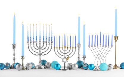 Photo of Hanukkah celebration. Composition with different menorahs and festive baubles on table against white background