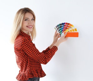 Young woman with color palette on white background