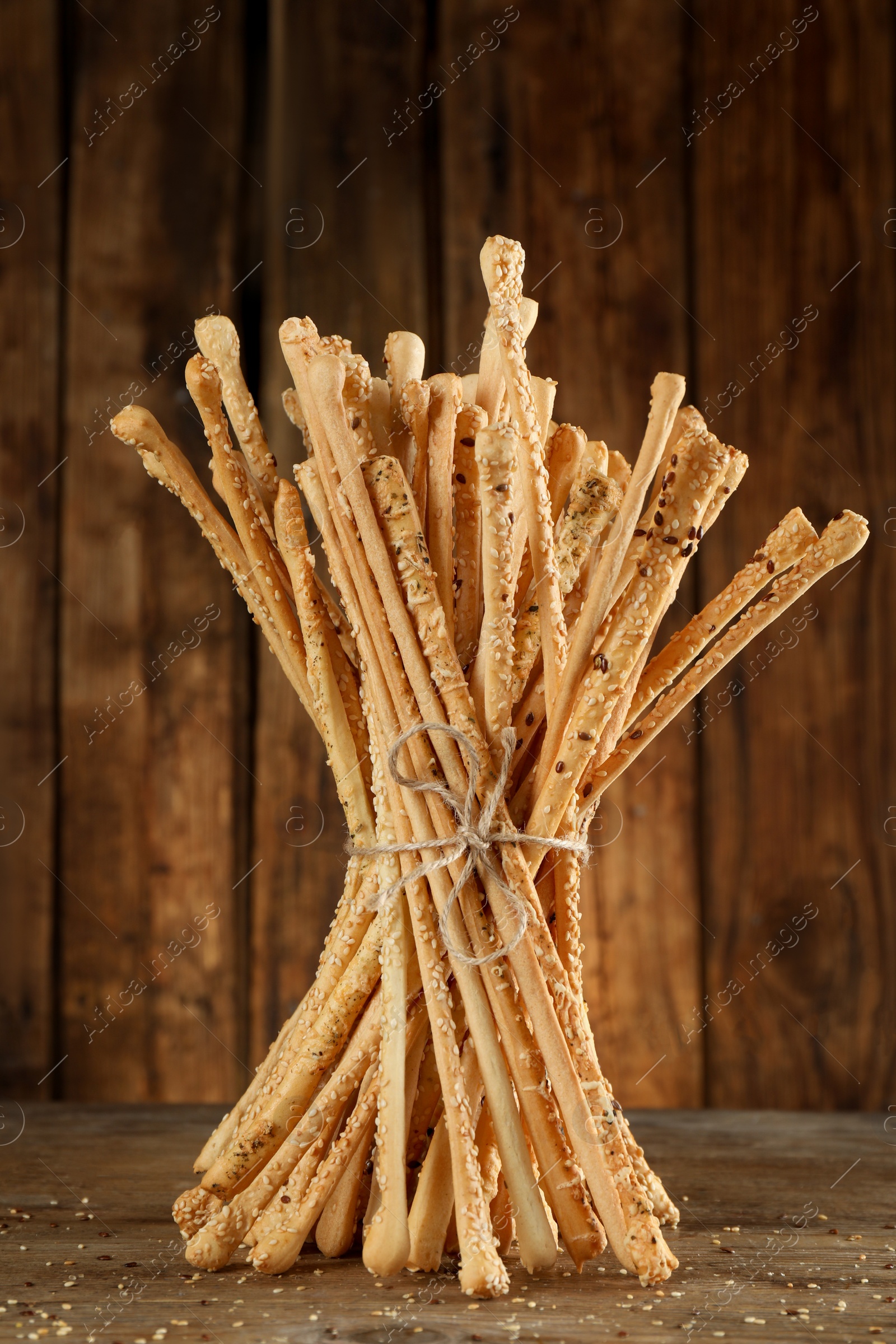 Photo of Bunch of delicious grissini sticks on wooden table