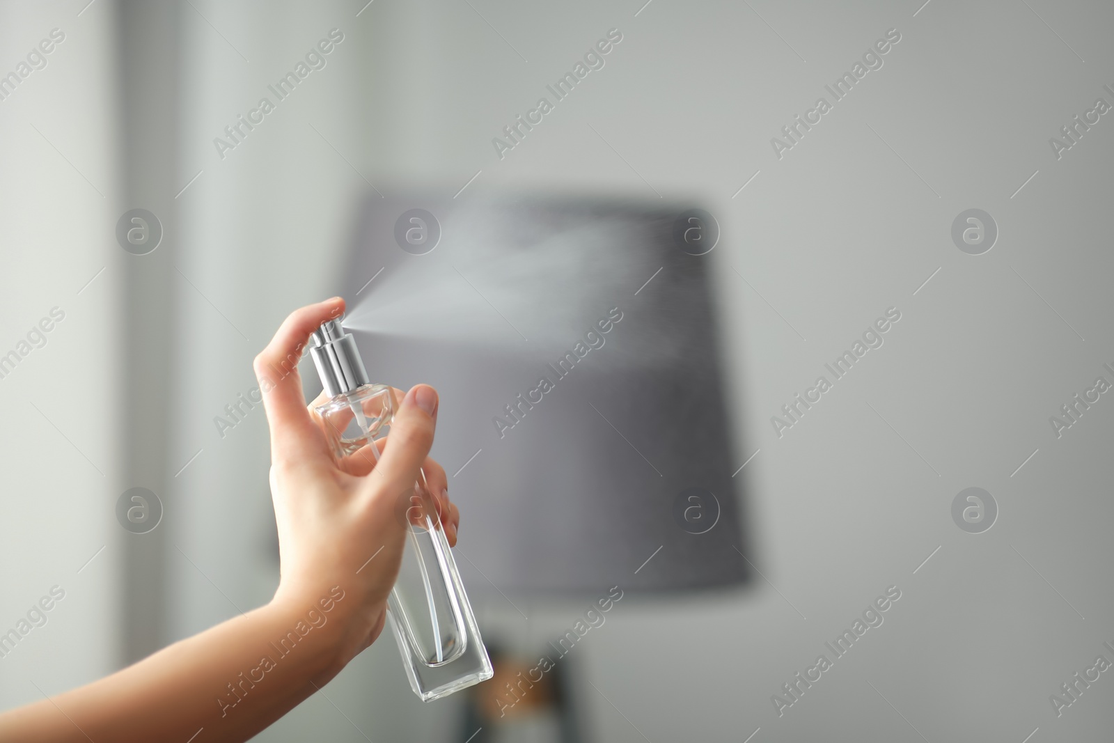 Photo of Woman spraying air freshener indoors closeup. Space for text