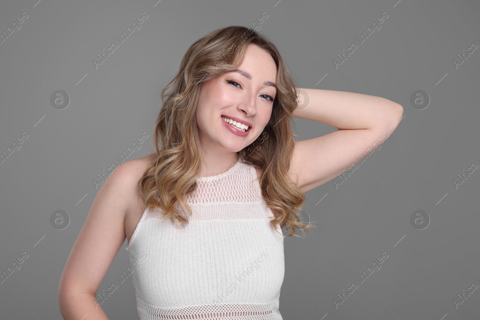 Photo of Portrait of smiling woman on grey background