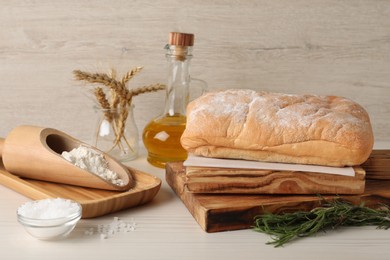 Photo of Composition with fresh crispy ciabatta on white wooden table