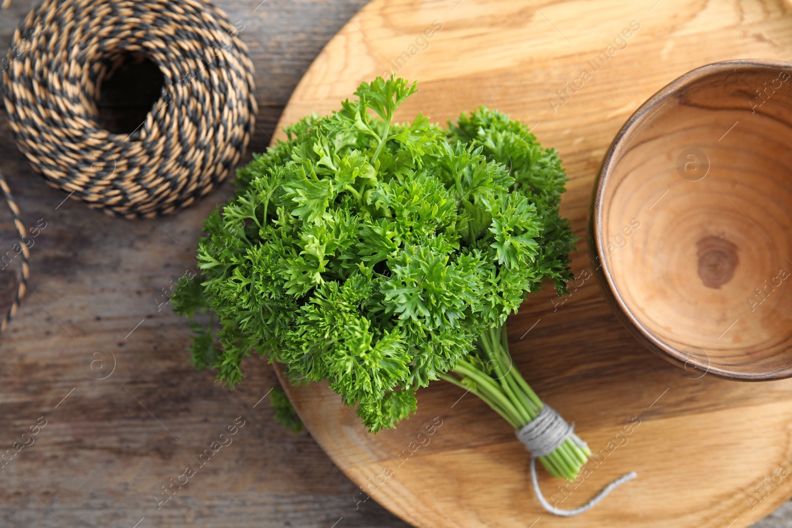 Photo of Dishware and fresh green parsley on wooden background, top view