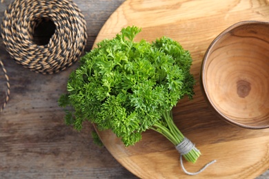 Dishware and fresh green parsley on wooden background, top view