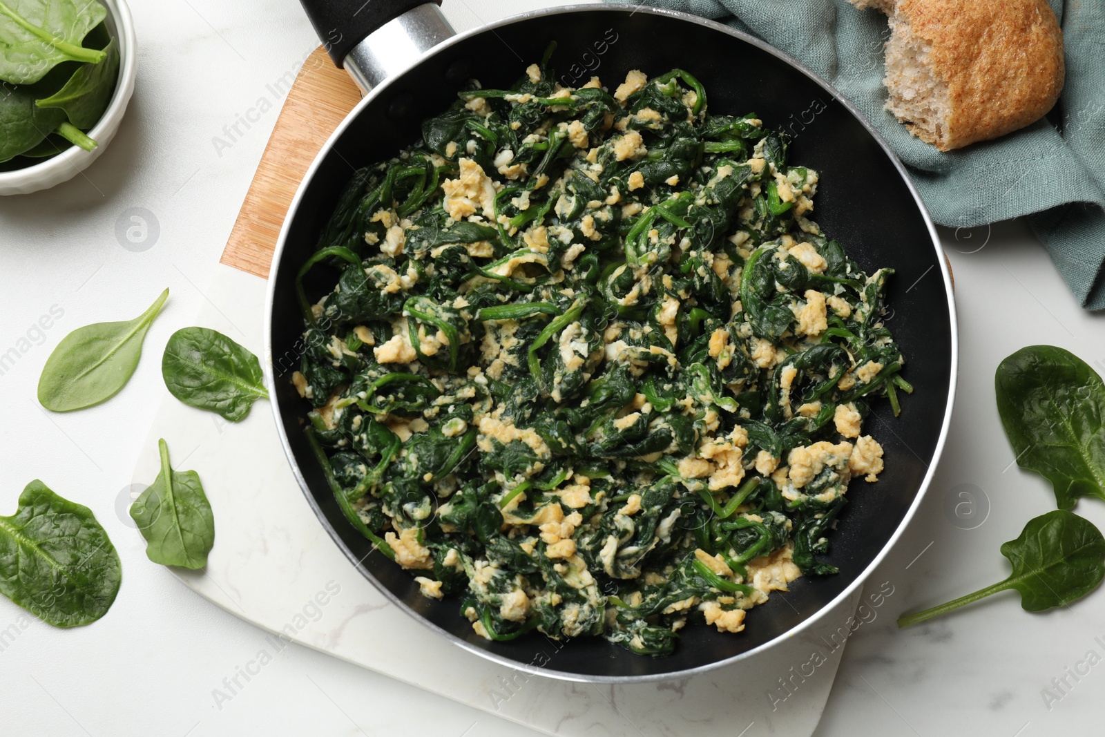 Photo of Tasty spinach dip with eggs in dish served on white table, flat lay