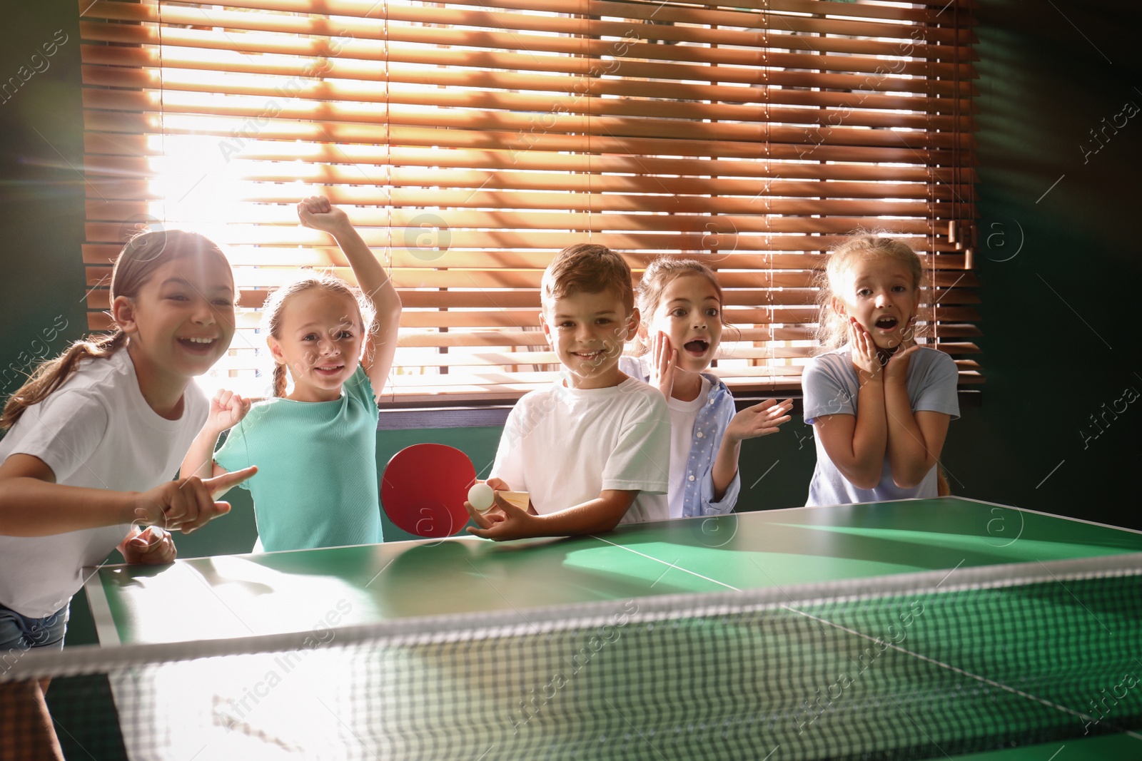 Photo of Cute happy children playing ping pong indoors