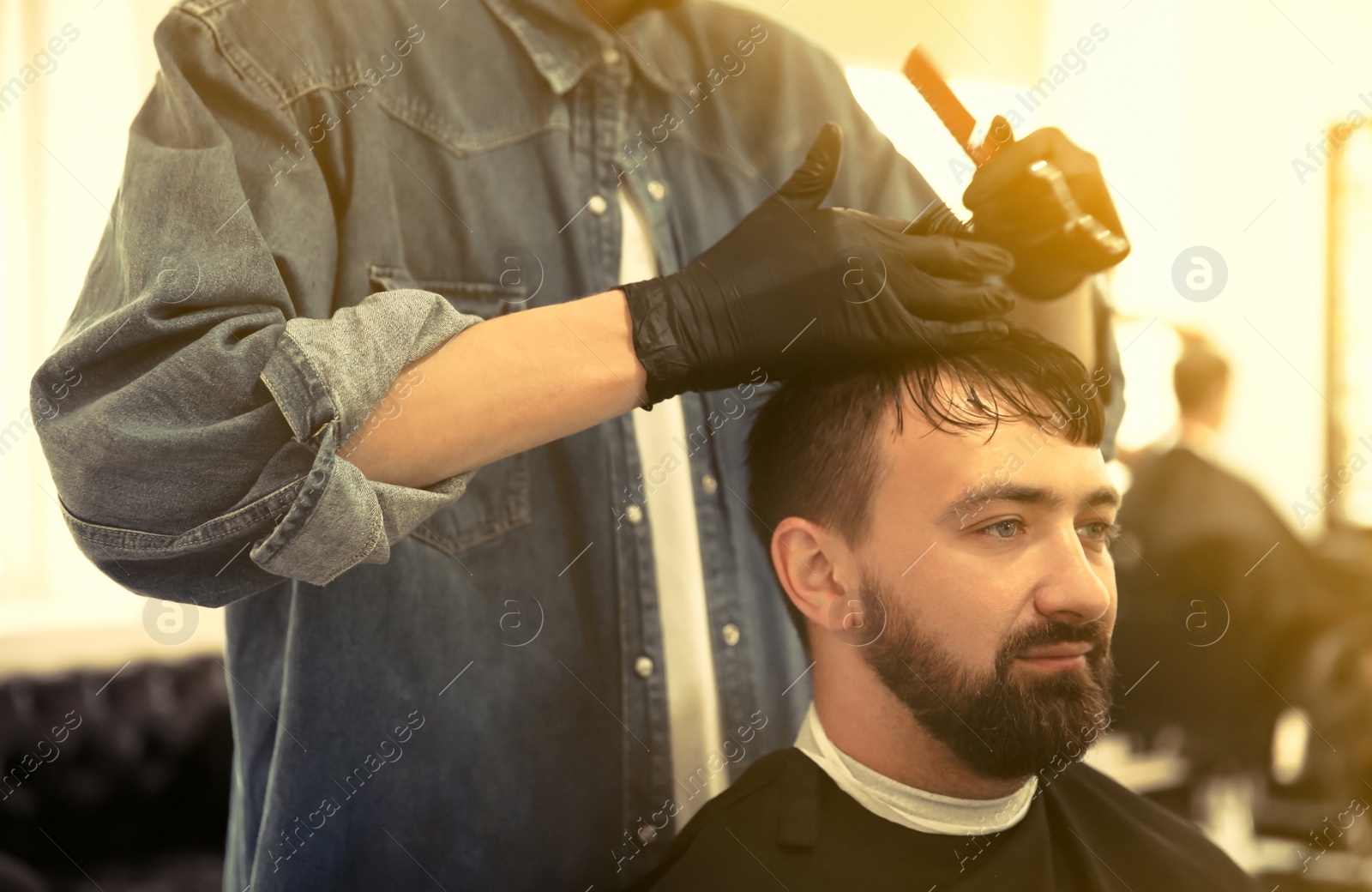 Image of Professional barber working with client in hairdressing salon