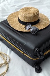 Photo of Suitcase packed for trip and summer accessories on bed