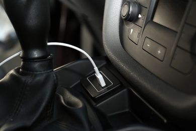 Photo of White USB charging cable plugged in inside modern car