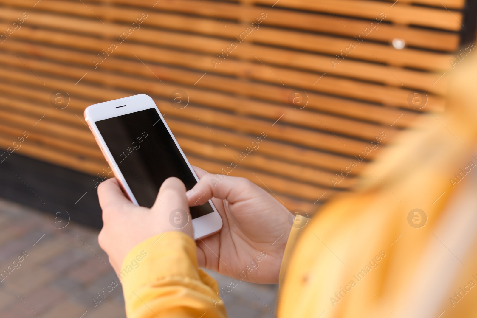 Photo of Young woman using phone outdoors, closeup