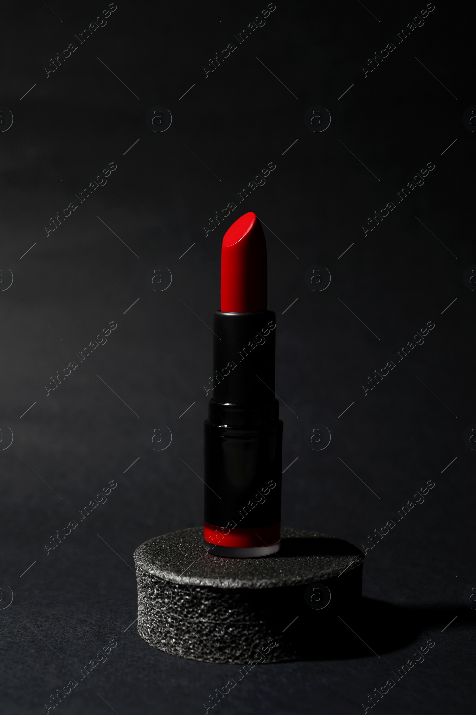 Photo of Beautiful glossy red lipstick on black background