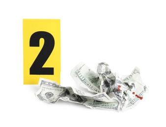 Photo of Bloody crumpled dollars and crime scene marker with number two isolated on white