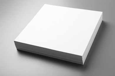 Photo of Stack of blank paper sheets for brochure on grey background. Mock up