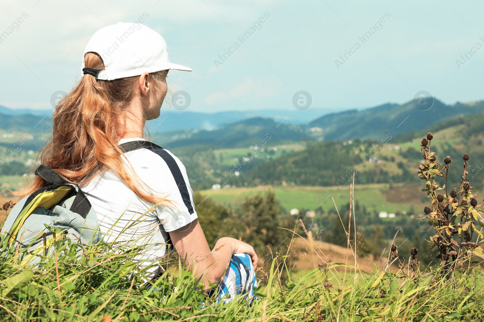 Photo of Woman with backpack in wilderness. Mountain landscape