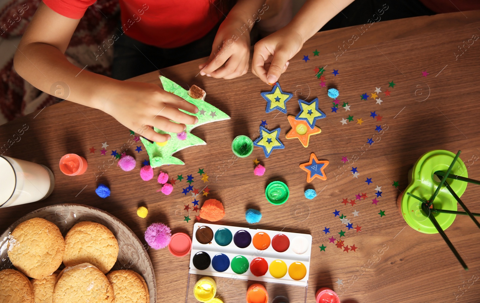 Photo of Little children decorating Christmas tree of foam plastic at table, top view