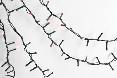 Beautiful Christmas lights on white background, top view