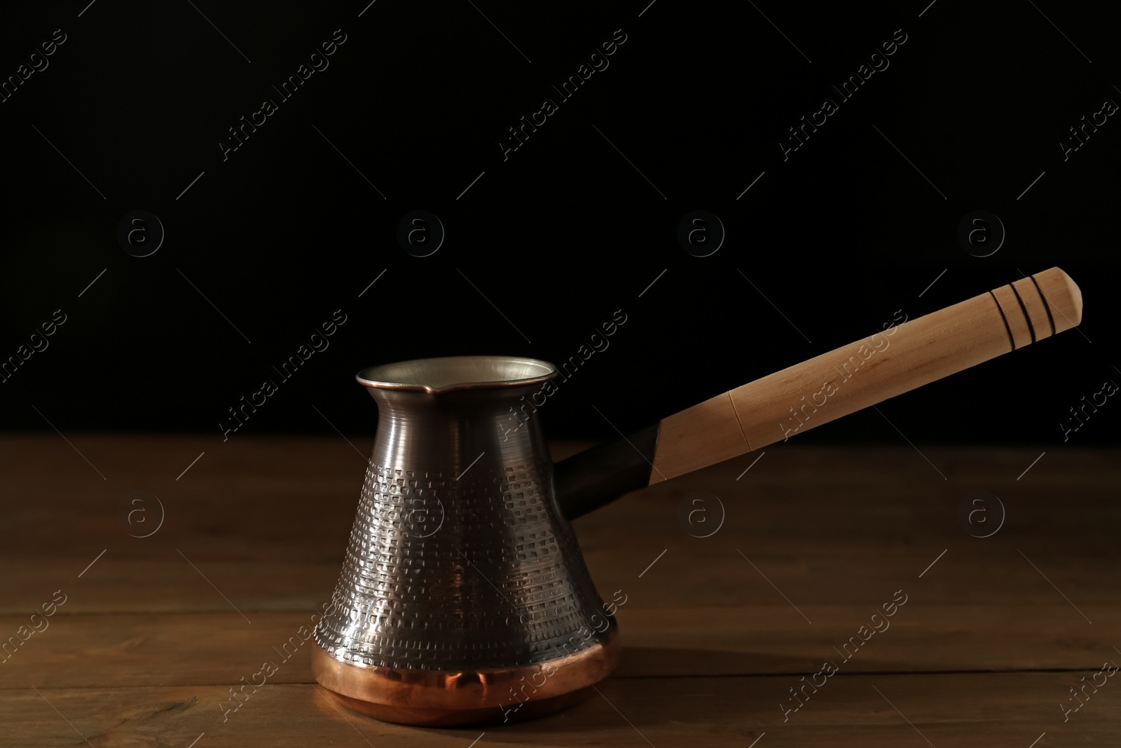 Photo of Beautiful copper turkish coffee pot on wooden table