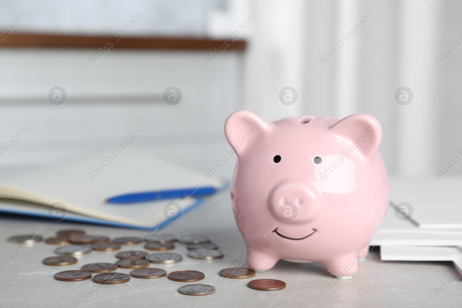 Photo of Piggy bank and coins on light table indoors, space for text. Money savings