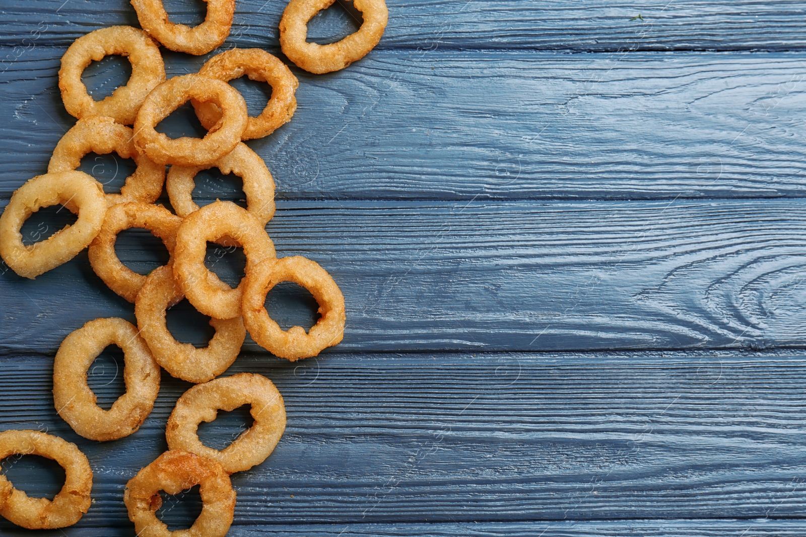 Photo of Flat lay composition with fried onion rings on wooden background