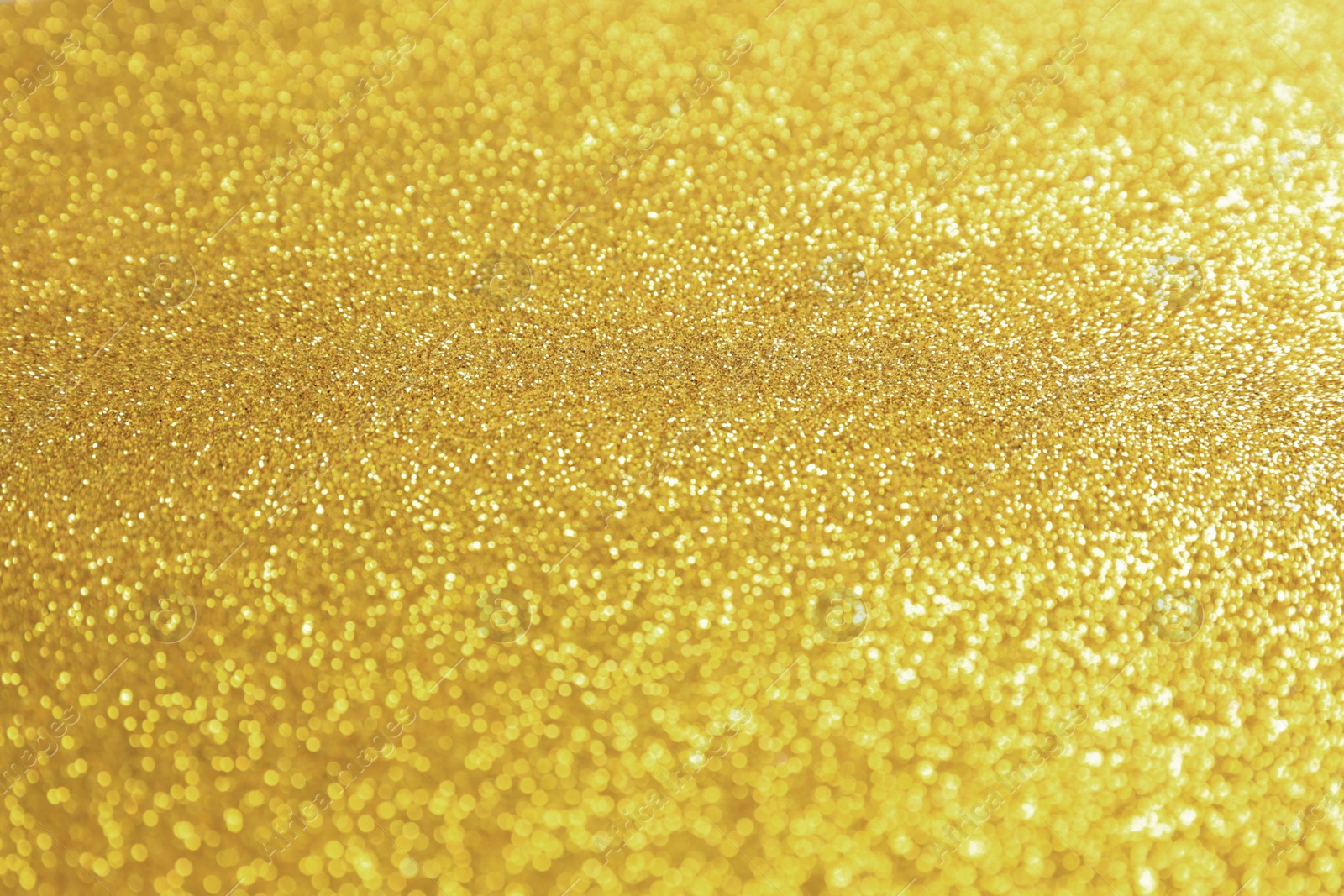 Photo of Beautiful golden shiny glitter as background, closeup