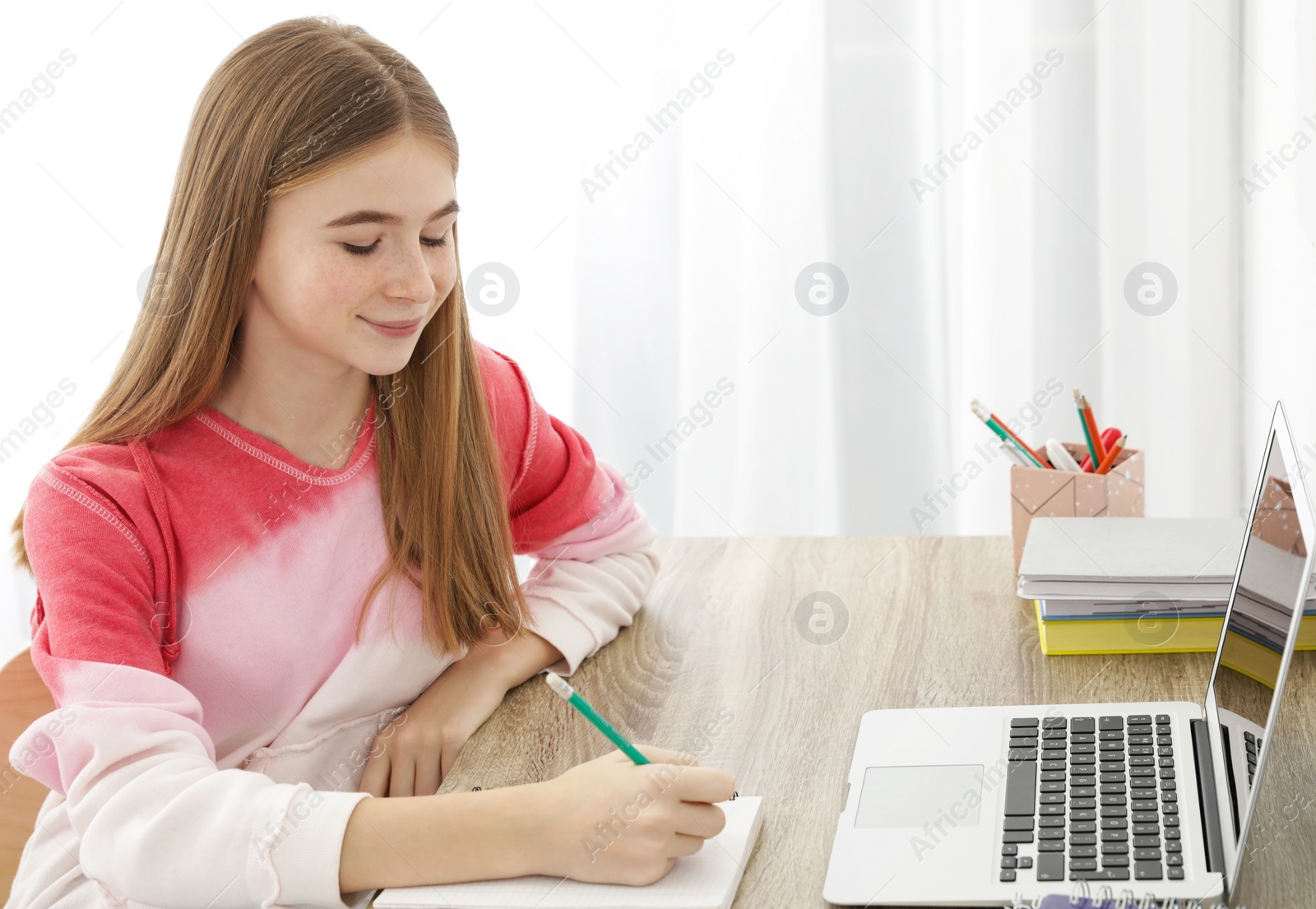 Photo of Teenager girl doing her homework at desk