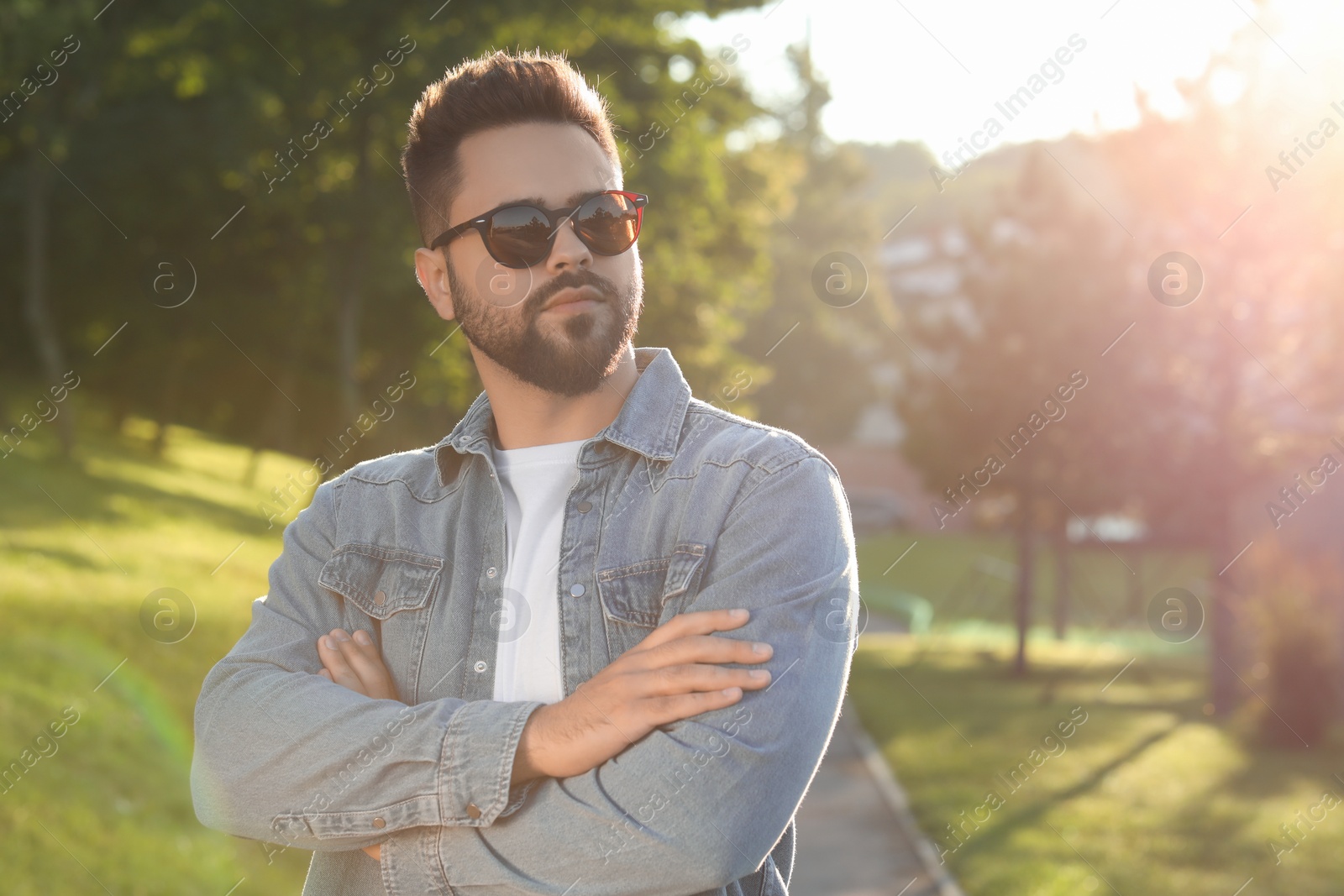 Photo of Handsome man wearing sunglasses in park, space for text