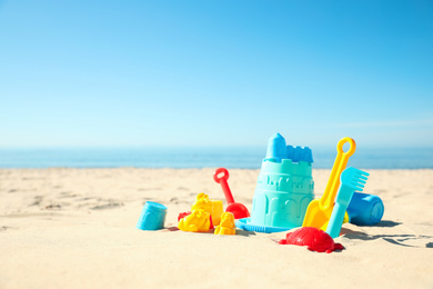 Different child plastic toys on sandy beach