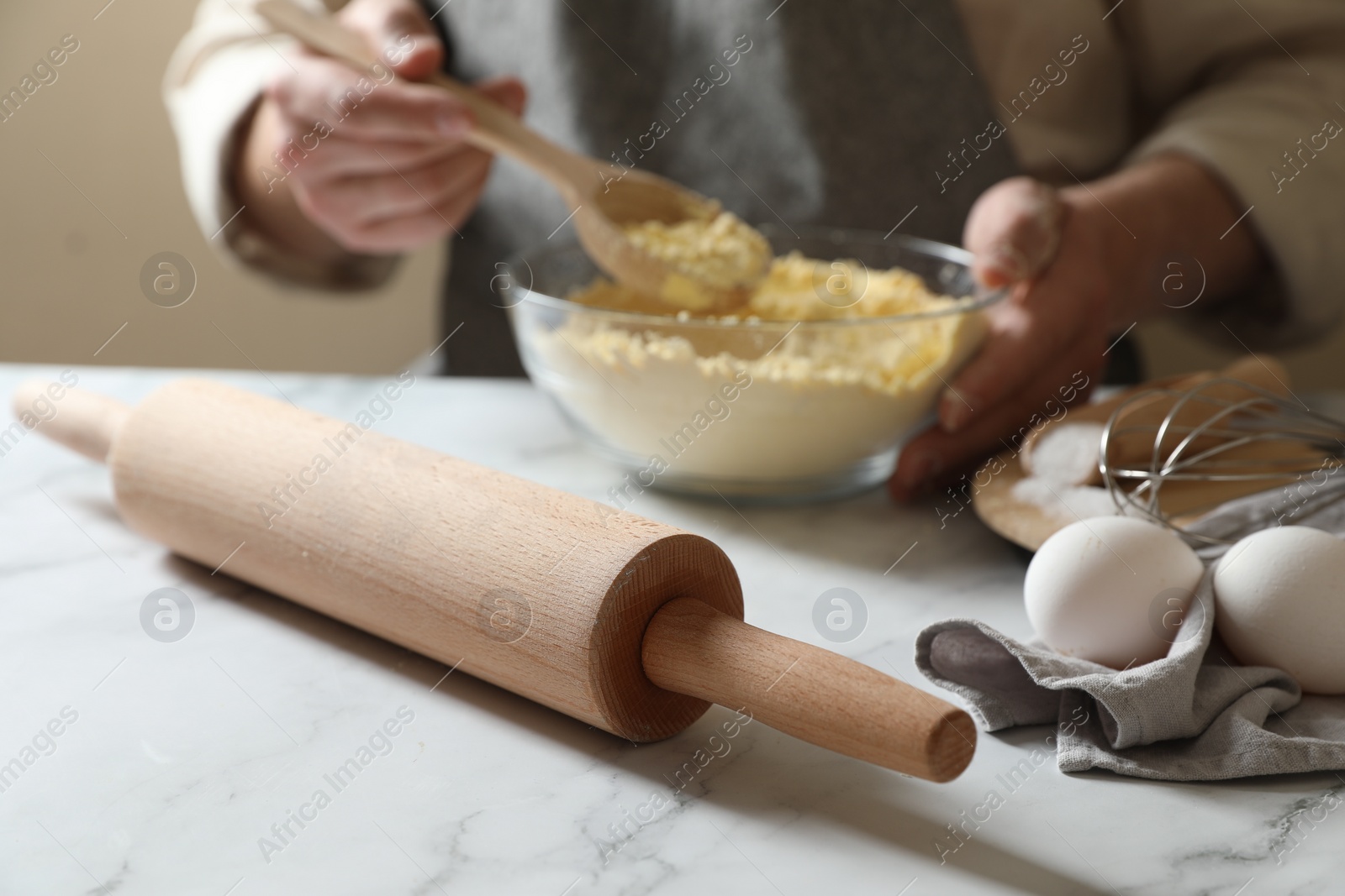 Photo of Man making dough at white table, selective focus