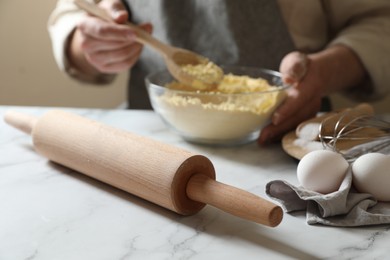 Man making dough at white table, selective focus