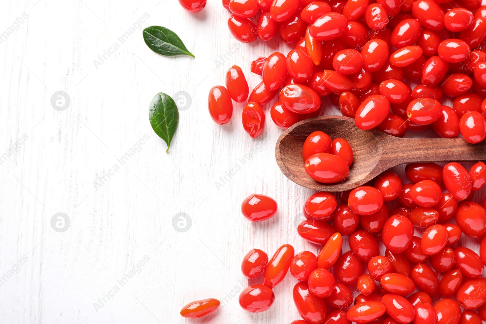 Photo of Flat lay composition with fresh ripe goji berries on white wooden table. Space for text