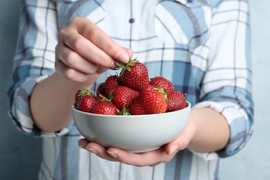 Photo of Woman holding bowl with tasty fresh strawberries, closeup