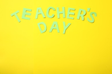 Photo of Words TEACHER'S DAY on yellow background, flat lay. Space for text