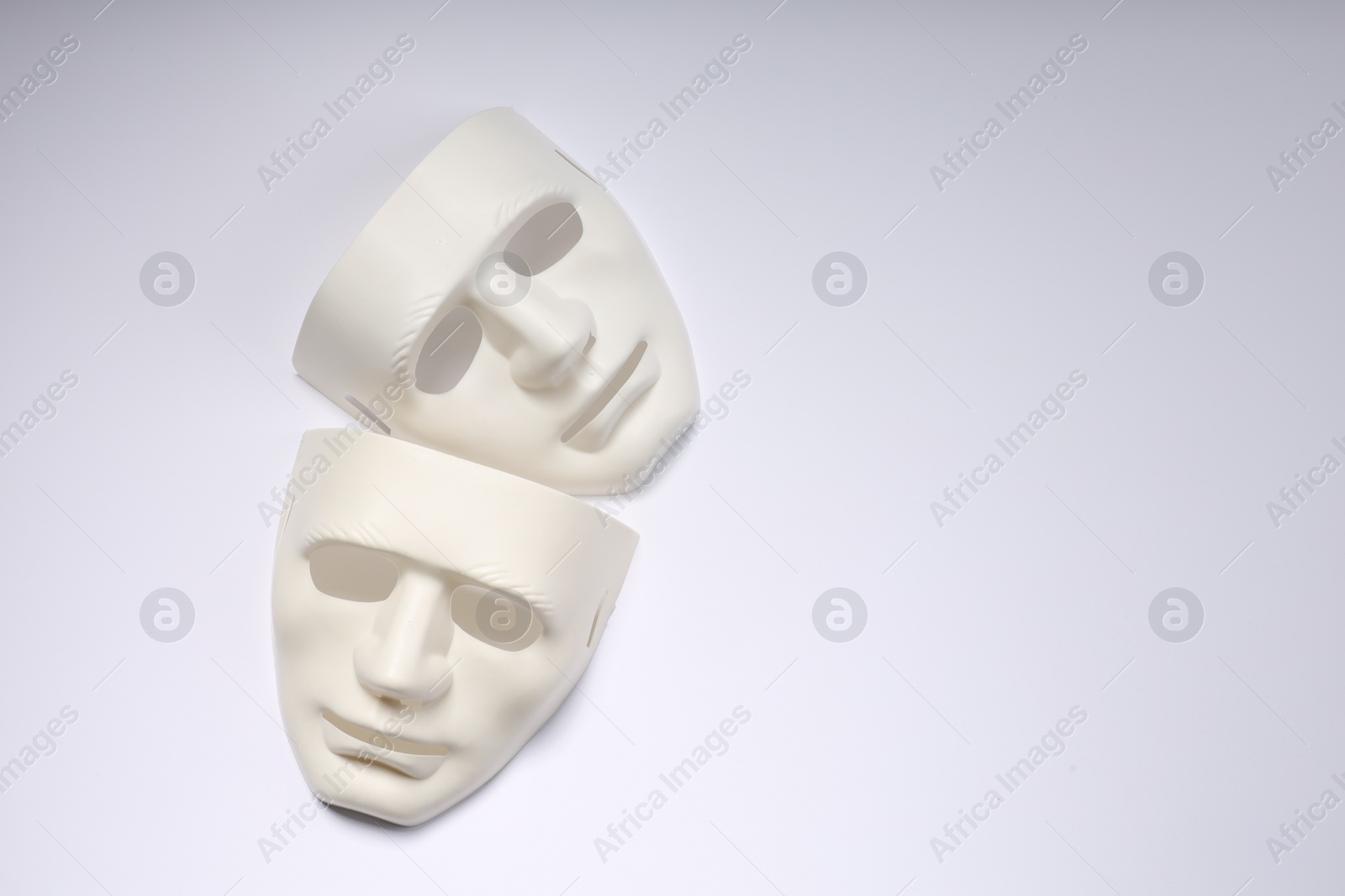 Photo of Theater arts. Two masks on white background, top view. Space for text