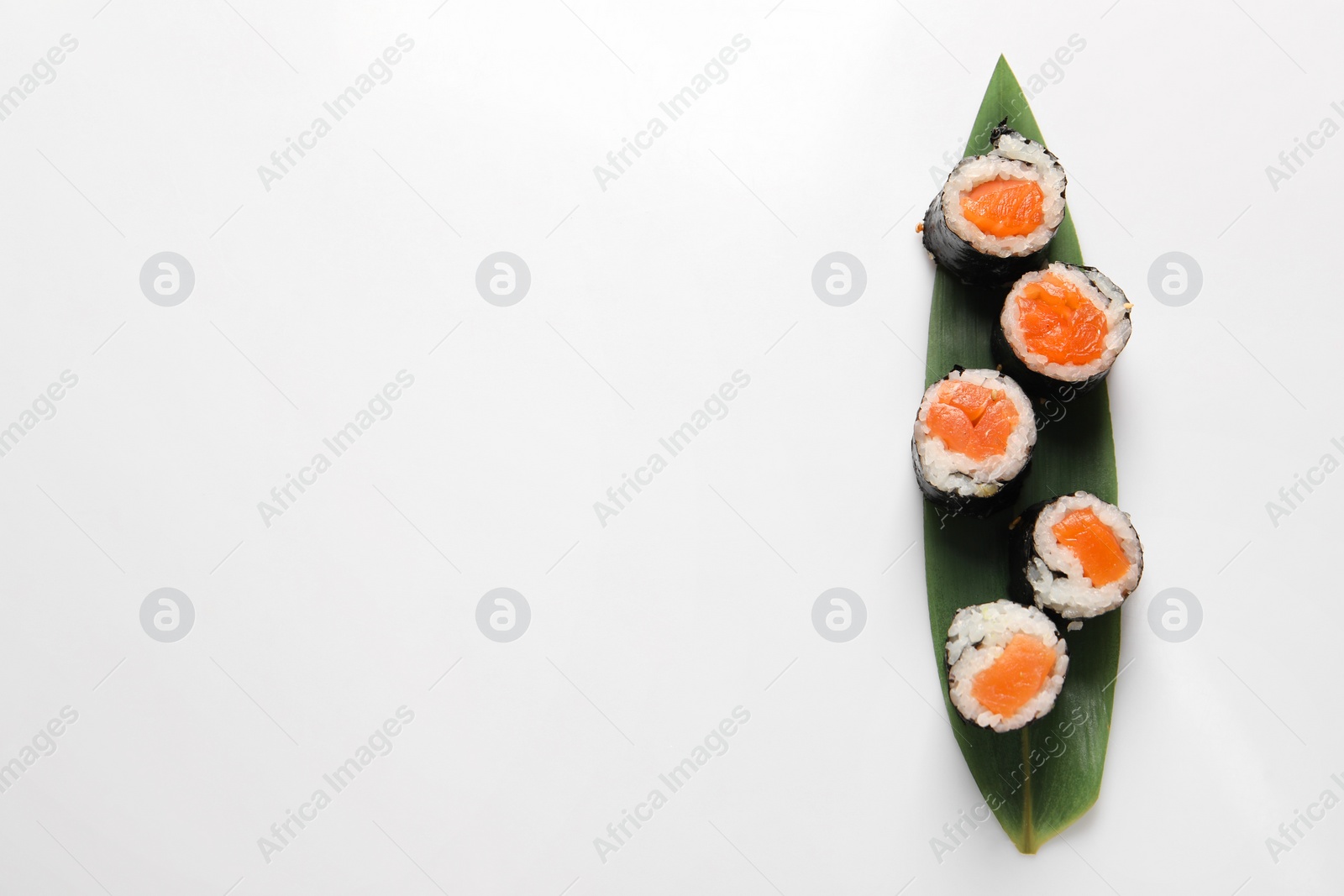 Photo of Delicious sushi rolls with salmon on white background, top view. Space for text