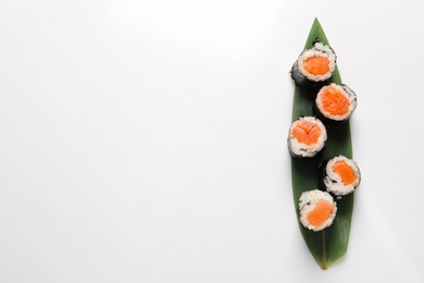 Photo of Delicious sushi rolls with salmon on white background, top view. Space for text