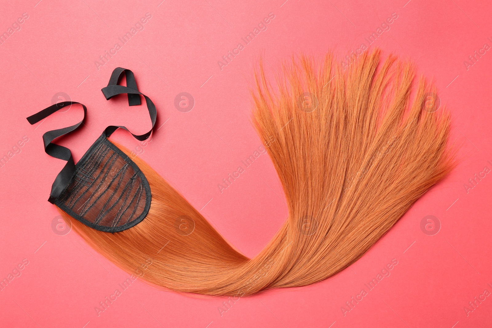 Photo of Lock of straight red hair on color background, top view